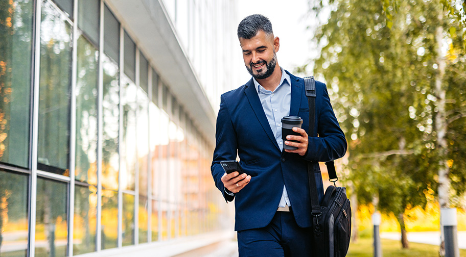 Man walking and looking at his phone.